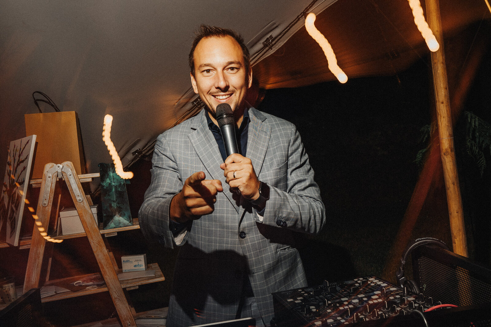 Martin Cihlář moderuje večer za pultem ve svatebním stanu s teplým osvětlením
