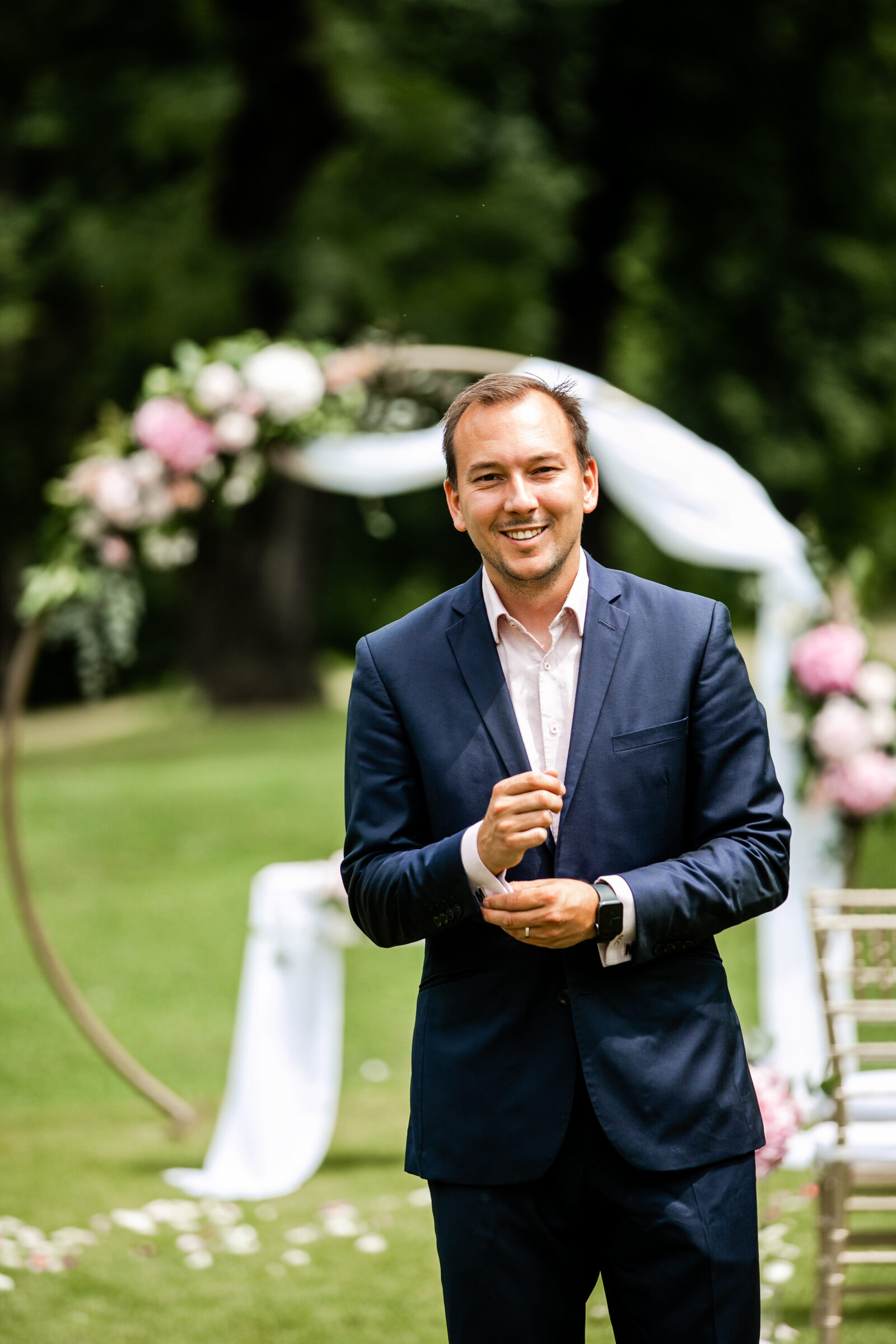 Martin Cihlář před květinovým obloukem připravený na venkovní obřad